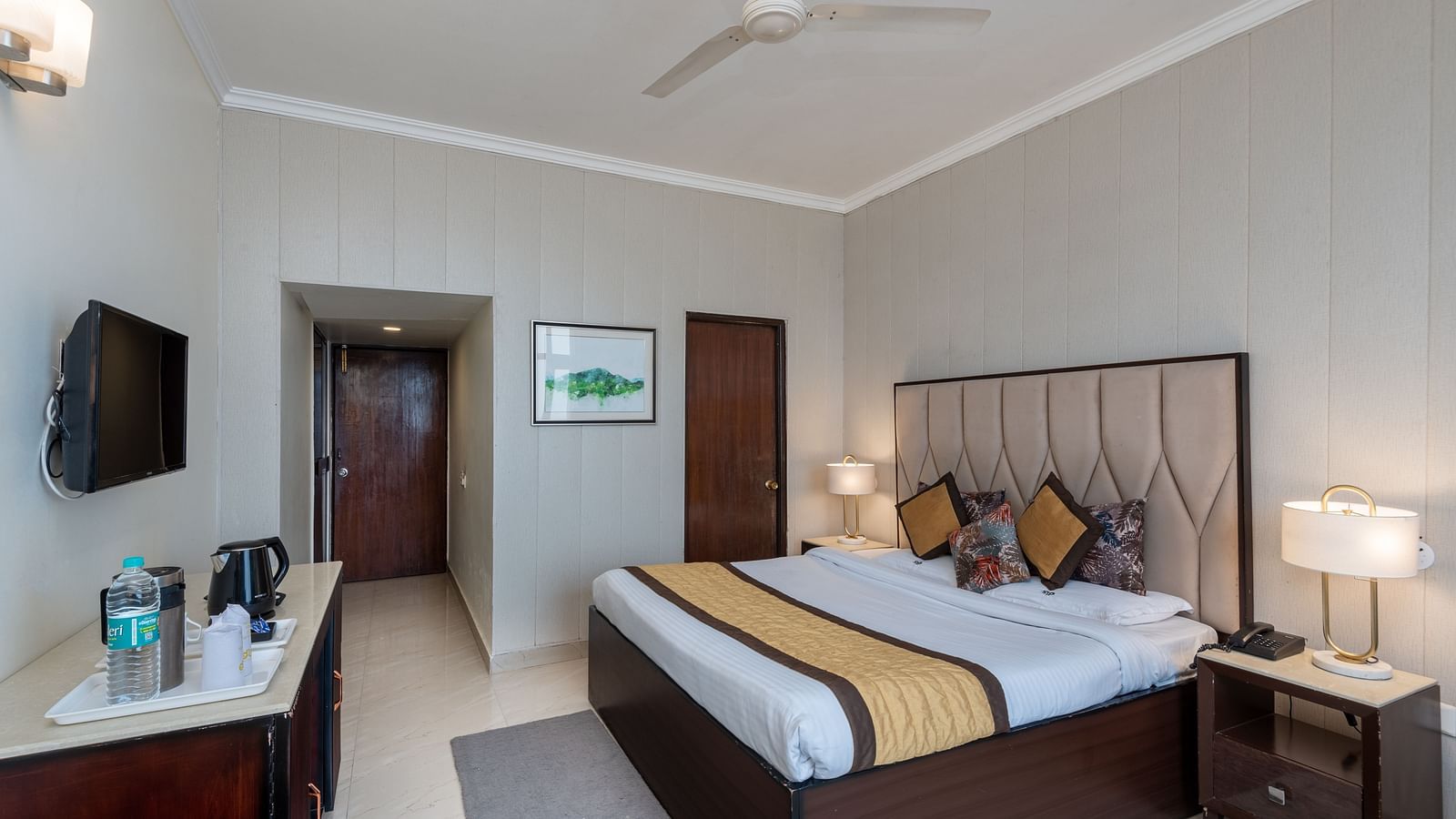 Image of a deluxe room featuring a king size bed with a side table and a lamp | DLS The Pearl